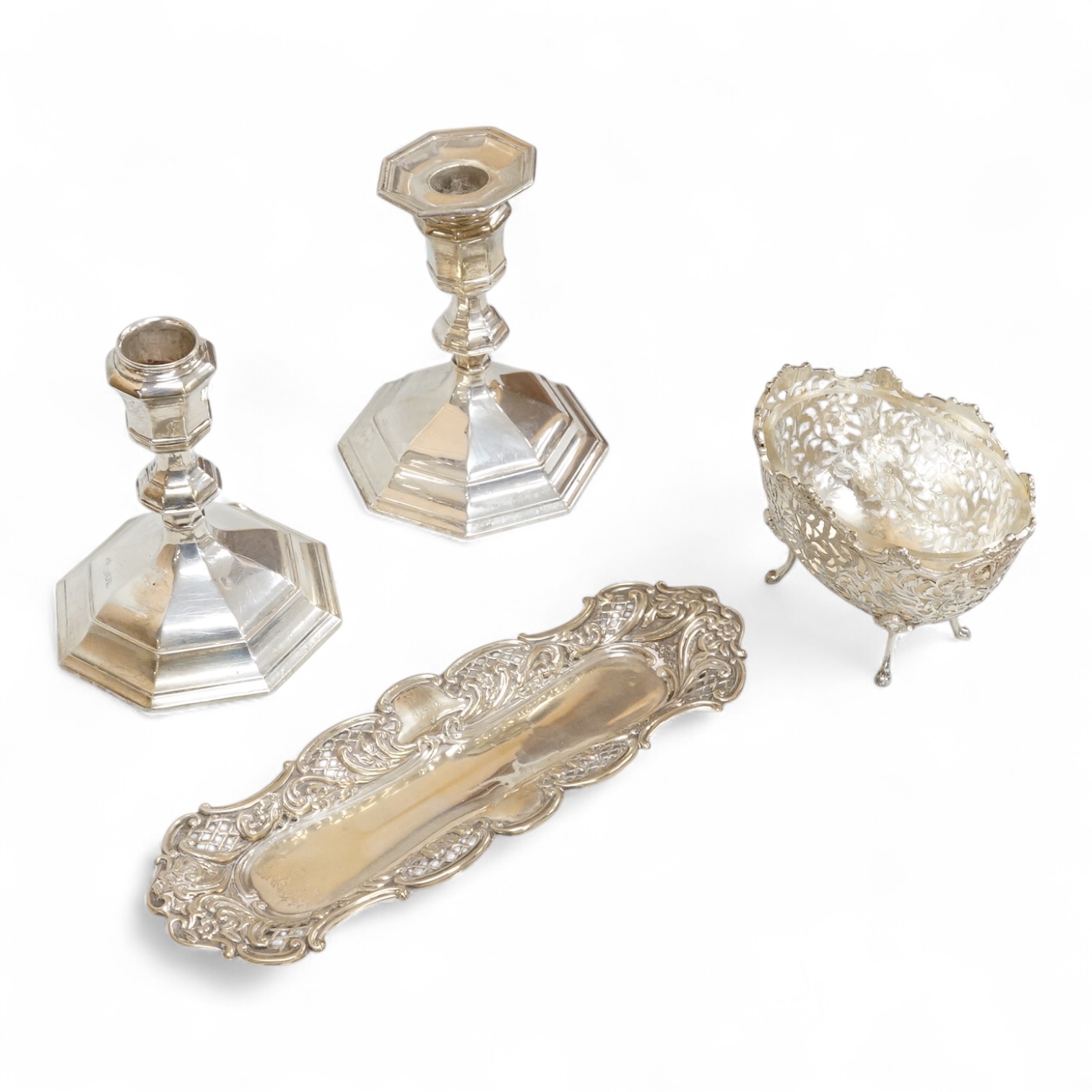 A pair of Edwardian silver mounted octagonal dwarf candlesticks by William Hutton & Sons, London, 1905, 12.7cm, weighted, one lacking sconce, together with a silver pin tray a continental sugar bowl with glass liner and